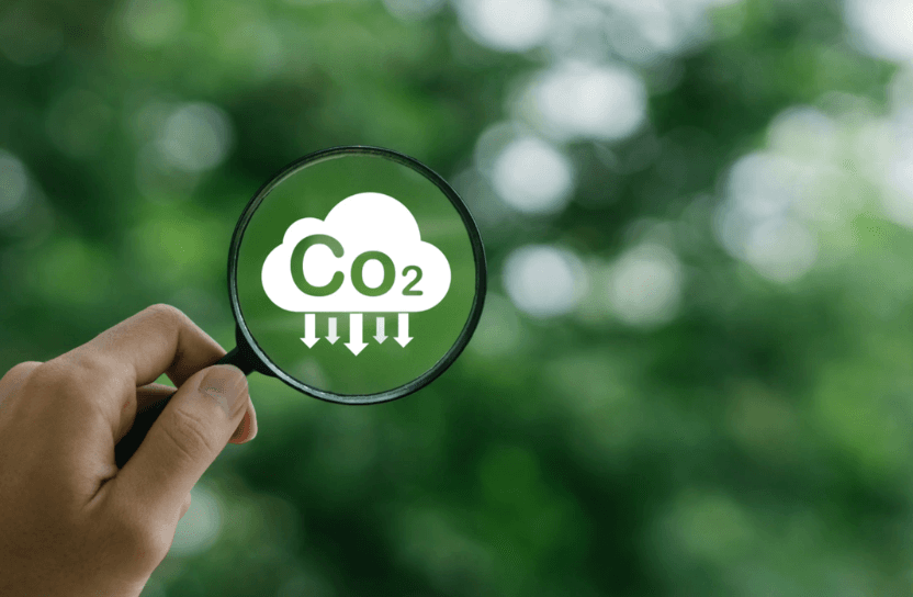 A magnifying glass holding up against a cloud with the text "co2" in it.